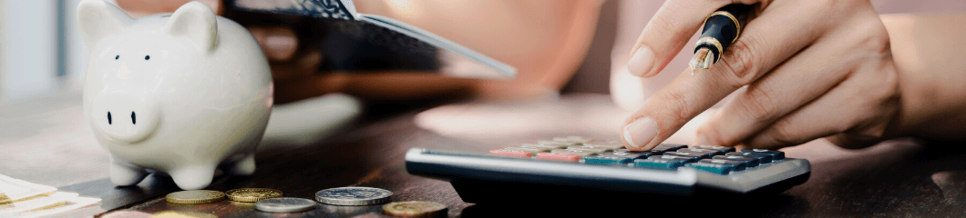 Calculatrice à côté d'une tirelire